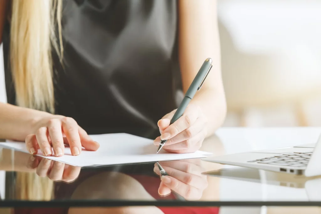 Women With Blond Hair Signing A Document.