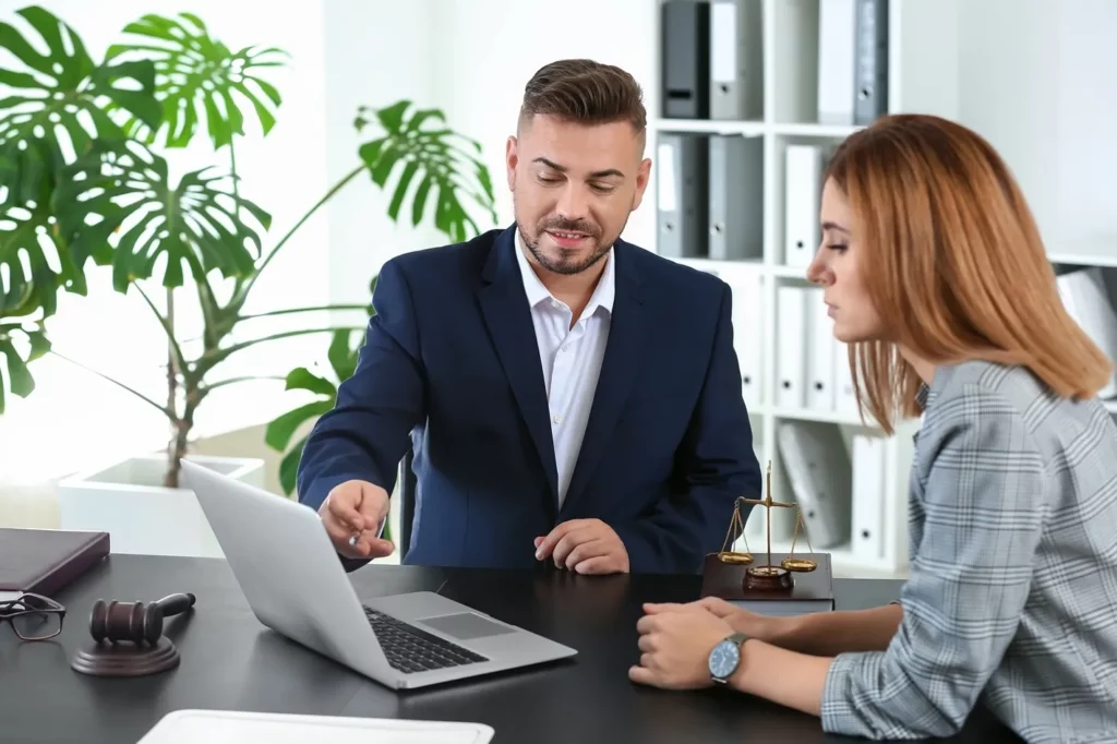 An Attorney Reviewing Information On His Laptop With A Client.