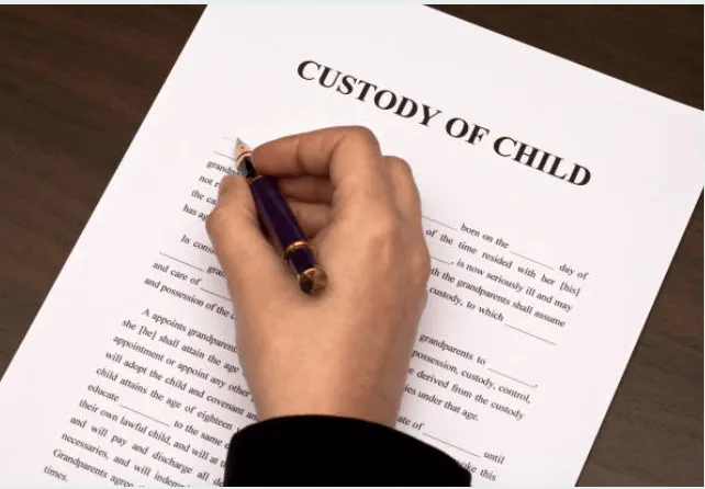 A Person Filling Out A Custody Of Child Form.